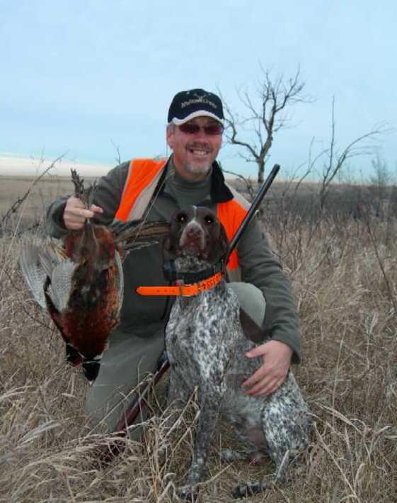 Photo of Gordon Burton with Buster and pheasants.